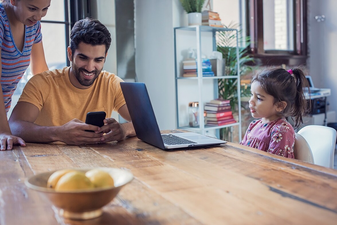 familia con celular y una laptop