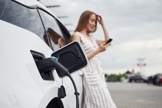 Chica cargando un auto electrico