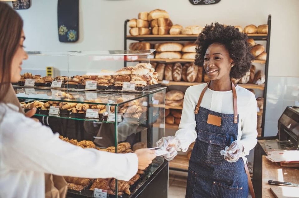 mujer en panaderia recibiendo pago con tarjeta 